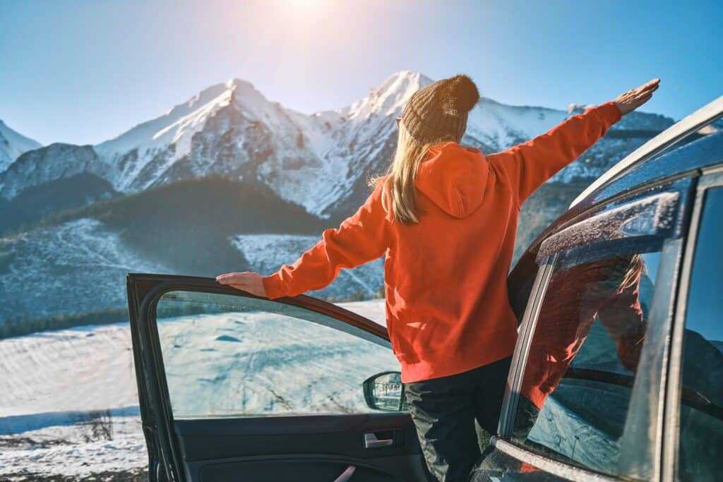 Woman opening car door after holiday travel