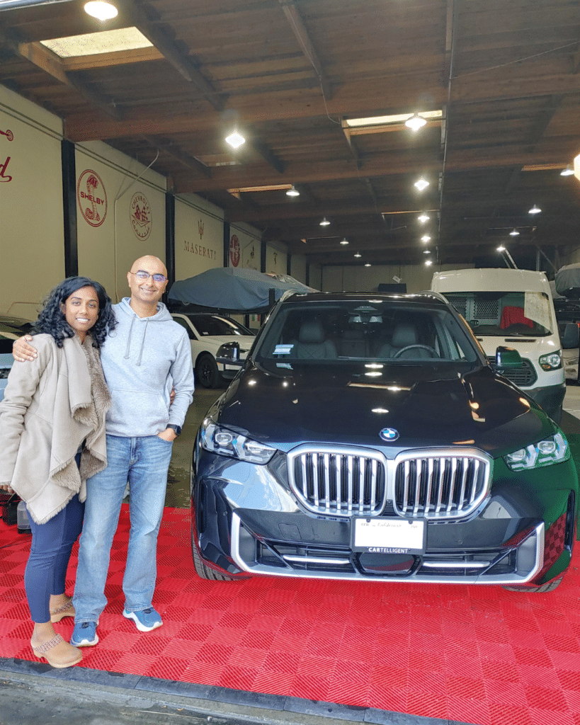 Man and woman picking up 2025 BMW X5 from Cartelligent in San Francisco, CA