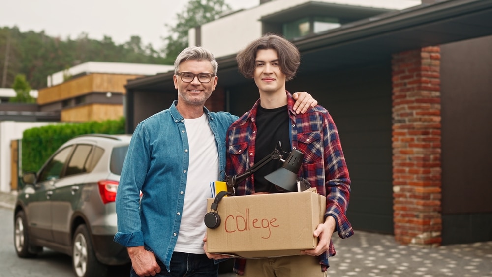 Father And His College Student Son Standing Outside In Yard